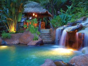 福尔图纳阿雷纳尔温泉度假酒店及Spa的瀑布,瀑布在游泳池中间,有瀑布