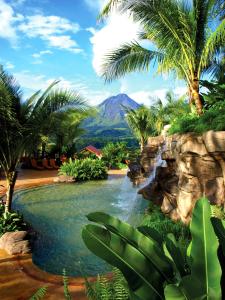 福尔图纳阿雷纳尔温泉度假酒店及Spa的拥有瀑布、棕榈树和山脉的度假胜地