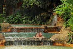 福尔图纳阿雷纳尔温泉度假酒店及Spa的男人和女人在瀑布中游泳