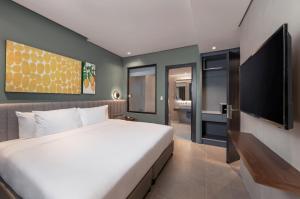 宿务Summit Galleria Cebu的一间卧室配有一张大床和一台平面电视
