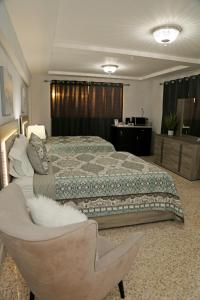 伊莎贝拉Itza-Bella Suites的一间大卧室,配有一张床和一把椅子