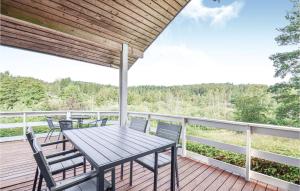 FemmøllerCozy Home In Ebeltoft With Sauna的木制甲板上配有桌椅