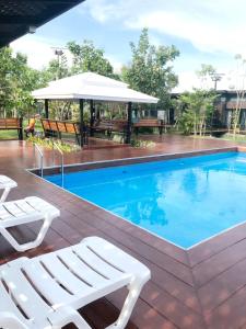 哈德超珊兰提拉克之家度假村的游泳池旁设有2把白色躺椅