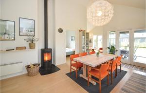 尼斯泰兹Stunning Home In Nysted With Wifi的一间带桌子和燃木炉的用餐室