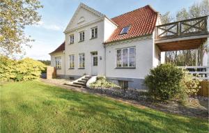 ÅrøAwesome Home In Assens With Sauna, Internet And Indoor Swimming Pool的白色的房子,有栅栏和院子