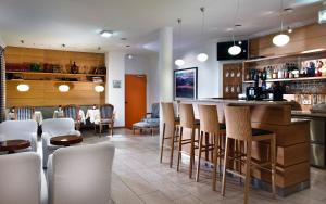 纽伦堡纽伦堡阿格尼斯舍弗酒店的餐厅内的酒吧,带白色椅子