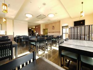 高崎高崎益尼斯古奇鲁特旅馆的用餐室配有桌椅