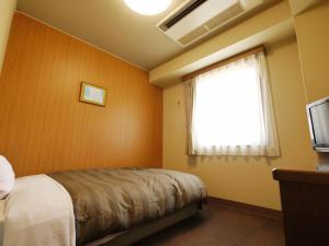 高崎高崎益尼斯古奇鲁特旅馆的一间卧室设有一张床、一个窗口和一台电视