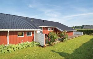 桑德比耶特Amazing Home In Sjlund With Wifi的一座红色的房子,有栅栏和院子