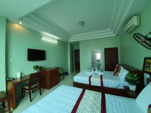 胡志明市Khách sạn Trường Sơn的酒店客房设有两张床和电视。