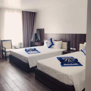 下龙湾Khách sạn Hải Quân - The Marine Hotel的酒店客房设有两张床和电视。
