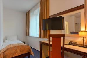 布伦瑞克塞勒托尔酒店的配有一张床和一台平面电视的酒店客房