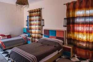 扎古拉小古堡酒店的一间卧室设有两张床和色彩缤纷的窗帘