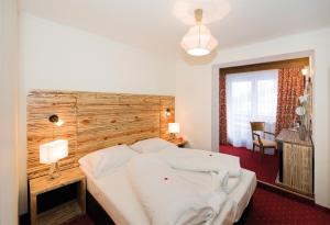 萨尔巴赫König - Joker Card included in Summer的一间卧室配有一张大床和木制床头板