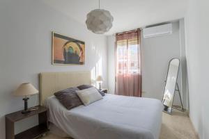 格拉纳达Granada Albaicín Aynadamar的卧室配有白色的床和窗户。