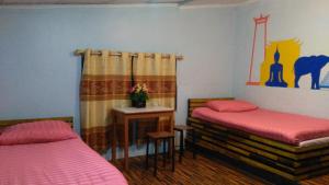 曼谷The Kong的一间卧室配有两张床和一张鲜花桌