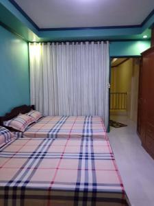 碧瑶Mary Chiang Baguio Transient House的一间卧室配有一张带铺着平底毯的床