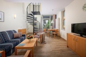 奥斯特巴德·哥伦吕根岛高堤公寓式酒店的带沙发和电视的客厅