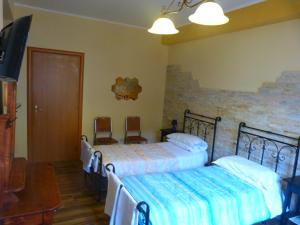 Preturo马萨里住宿加早餐旅馆的一间带两张床的卧室和一台电视
