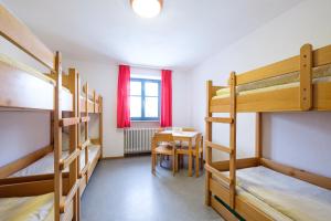 Trausnitz格特劳斯尼茨旅舍的宿舍间设有双层床和桌子。