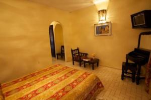 马拉喀什阿玛雷酒店的一间卧室配有一张床和一架钢琴