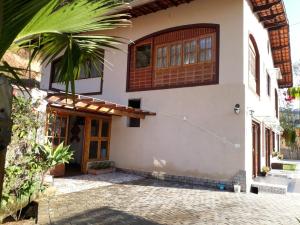 圣安东尼奥-杜皮尼亚尔Pousada Recanto das Marias的一座房子,前门和棕榈树