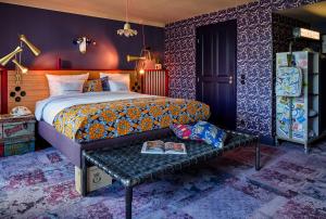 巴黎25hours Hotel Terminus Nord的一间卧室配有一张床和一张带书籍的长凳