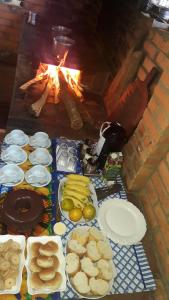 里奥阿西马Aconchego Caminho das Cachoeiras的餐桌,餐盘和壁炉