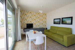 瓦斯托Residenza Alpaluba的客厅配有绿色沙发和桌子