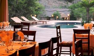 MacleantownPremier Resort Mpongo Private Game Reserve的一张带椅子的餐桌和一个游泳池