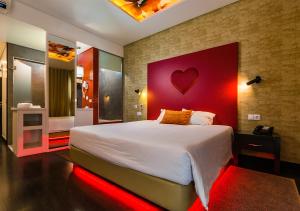 莱里亚Lisotel - Hotel & Spa的一间卧室配有一张大床和红色床头板
