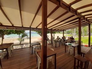 爱妮岛Duli Beach Resort的坐在甲板上的人,享有海滩美景