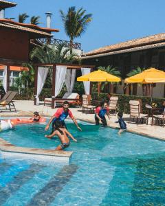 里约达欧特拉斯韦拉欧普拉亚酒店的一群人在游泳池玩耍