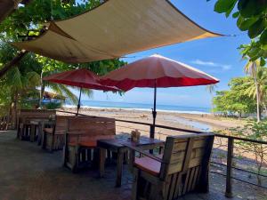 埃尔蒙特Esencia Nativa的海滩上的两张桌子和椅子及遮阳伞