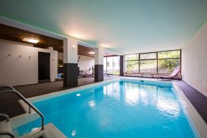 特伦托都鲁梅藤布里克酒店的大楼内一个蓝色的大型游泳池