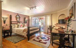 开普敦Inn-Style的一间卧室配有一张床、一张书桌和一台电视