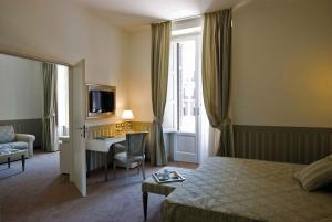 巴里JR Hotels Oriente Bari的配有一张床和一张书桌的酒店客房