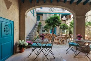 马翁哈迪德赛斯布鲁克斯精品酒店的一个带桌椅的户外庭院和一扇蓝色的门