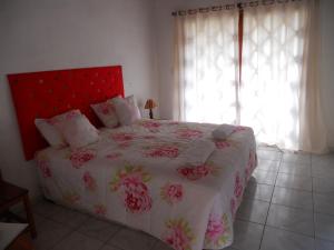 伊加图Art Hotel Cristal de Igatu的一间卧室配有一张大床和红色床头板