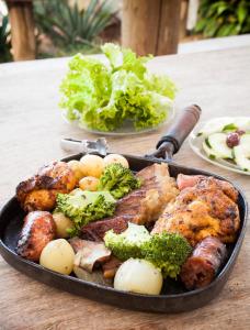 圣布兰卡法赞道农家乐的桌子上满是肉和蔬菜的锅