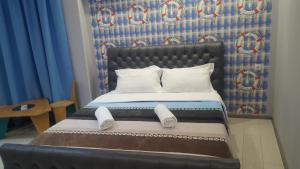 阿纳克利亚Hotel Cruise的一张带黑色床头板和白色枕头的床