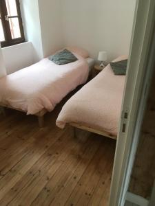 格鲁瓦Maison familiale Groix的铺有木地板的客房内的两张床