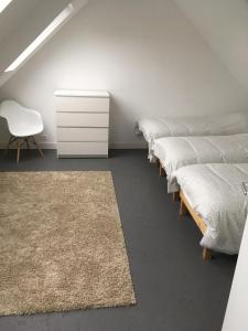 格鲁瓦Maison familiale Groix的一间白色梳妆台的房间的一排床位
