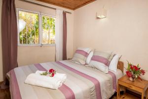塔那那利佛Villa ChezSoa, Antananarivo的一间卧室配有一张床,上面有两条毛巾
