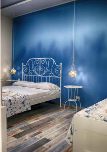 加埃塔La terrazza dei colori的蓝色卧室,配有床和桌子