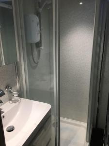 SwynnertonWoodland View - a place to escape的带淋浴和白色盥洗盆的浴室
