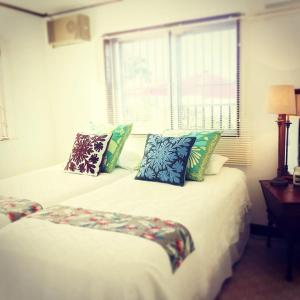 宜野湾市Old American House K-113的一间卧室配有两张带枕头的床和窗户。
