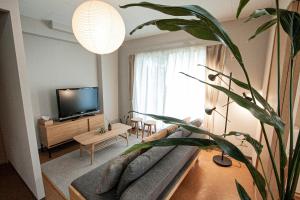 小樽UCHI Living Stay Otaru Suitengu的带沙发和电视的客厅