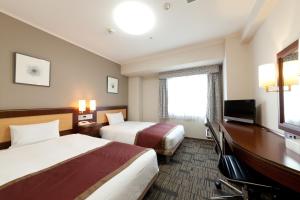 鹿儿岛鹿儿岛法华俱乐部酒店的酒店客房设有两张床和一台平面电视。
