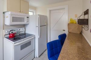 基韦斯特Leeward Isle的厨房配有白色冰箱和微波炉